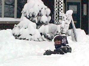 Xavier dans la neige devant la maison