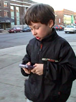 Xavier sur la rue jouant &agrave; Warioland 2 sur son Gameboy de Nintendo