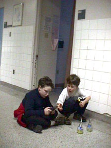 Xavier et son ami Guillaume jouant au Gameboy dans le corridor devant ta chambre tout en d&eacute;gustant de savoureuses Orangina