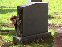 Xavier se cachant derrière une pierre tombale